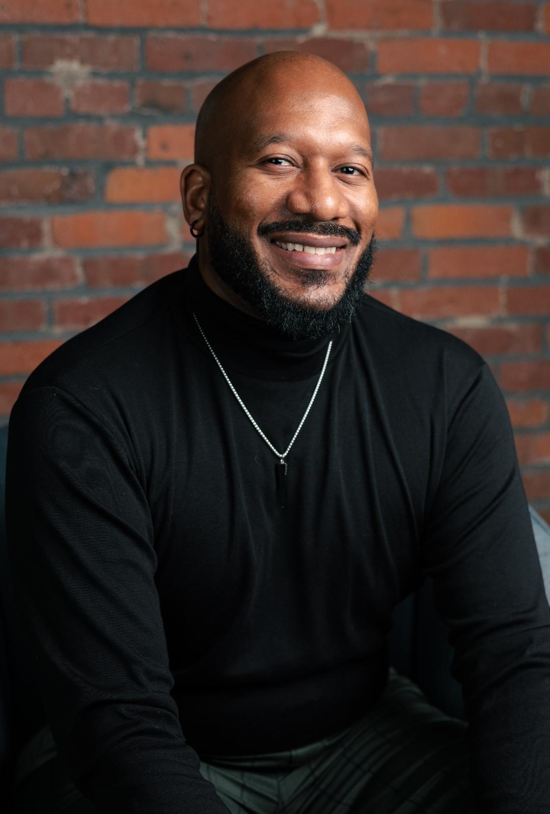 TC Brown in front of a brick wall